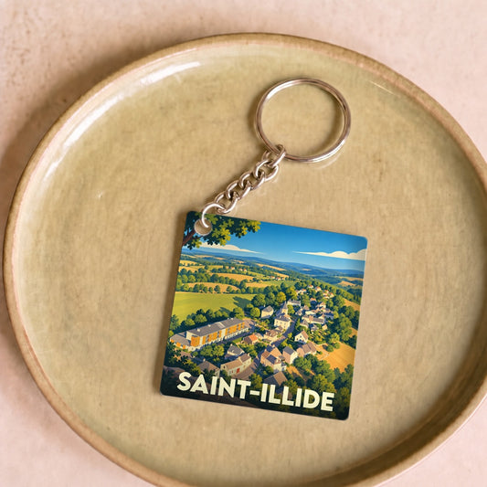 Porte-clés souvenir de la ville de Saint-Illide avec une illustration stylisée d'un paysage de campagne.