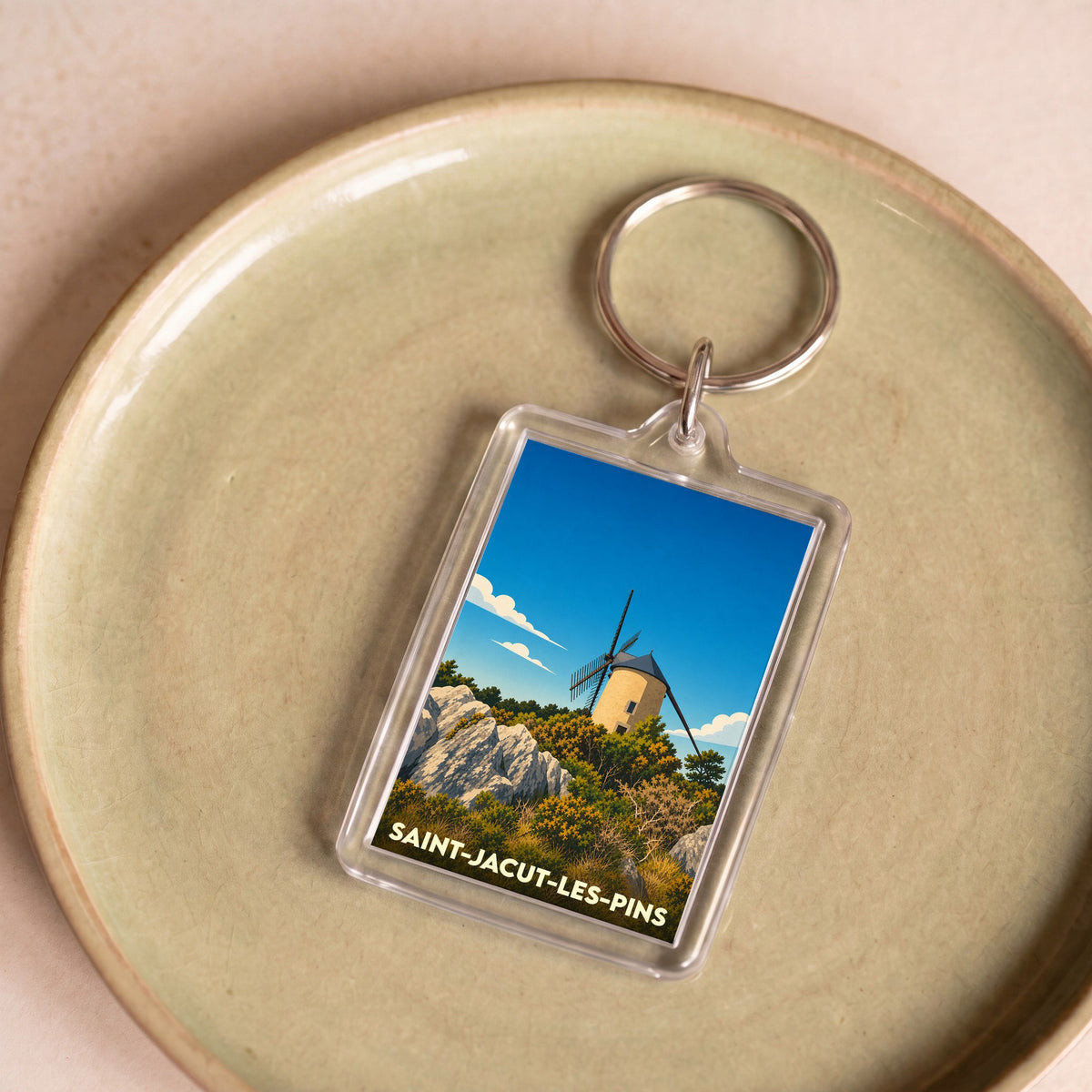 Porte-clés souvenir de la ville de Saint-Jacut-les-Pins avec une illustration stylisée d'un moulin.