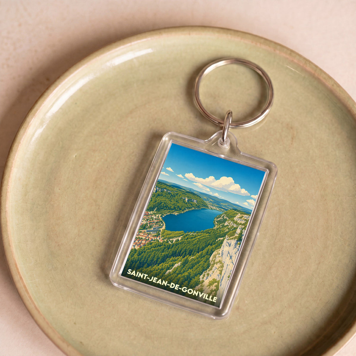 Porte-clés souvenir de la ville de Saint-Jean-de-Gonville avec une illustration stylisée de ses paysages naturels.