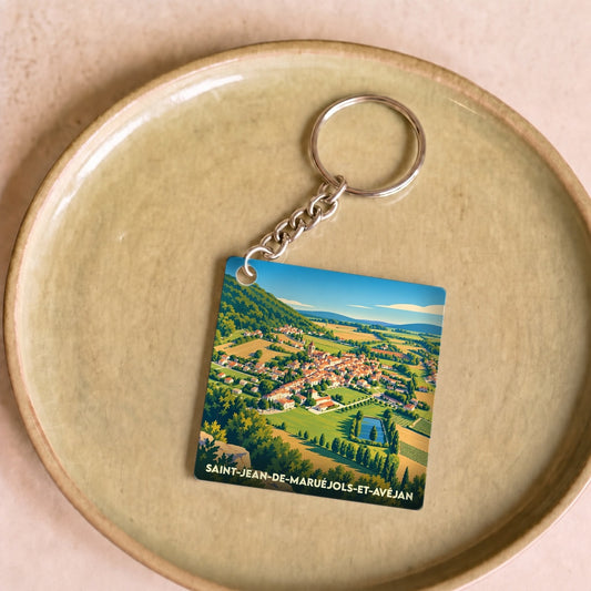Porte-clés souvenir de Saint-Jean-de-Maruéjols-et-Avéjan avec une illustration stylisée du village et de ses paysages environnants.