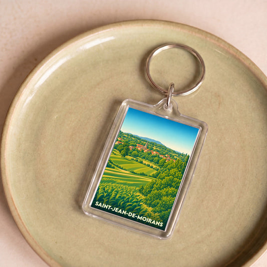 Porte-clés souvenir de la ville de Saint-Jean-de-Moirans avec une illustration stylisée de son paysage rural.