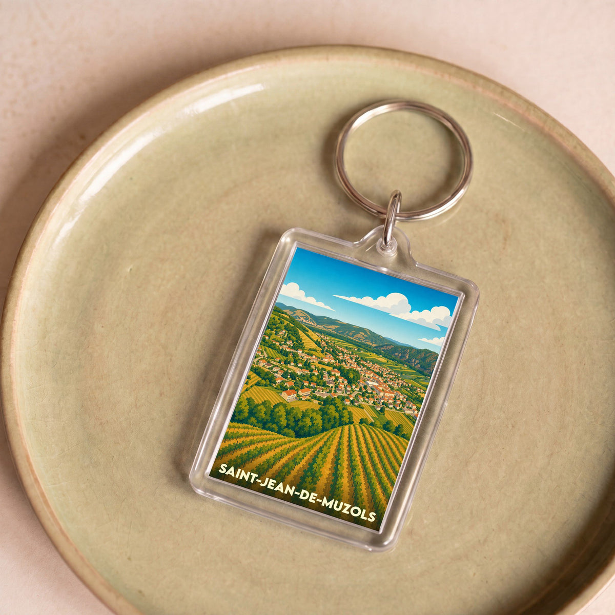 Porte-clés souvenir de la ville de Saint-Jean-de-Muzols avec une illustration stylisée de ses vignobles.
