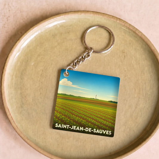Porte-clés souvenir de la ville de Saint-Jean-de-Sauves avec une illustration stylisée d'un paysage agricole.