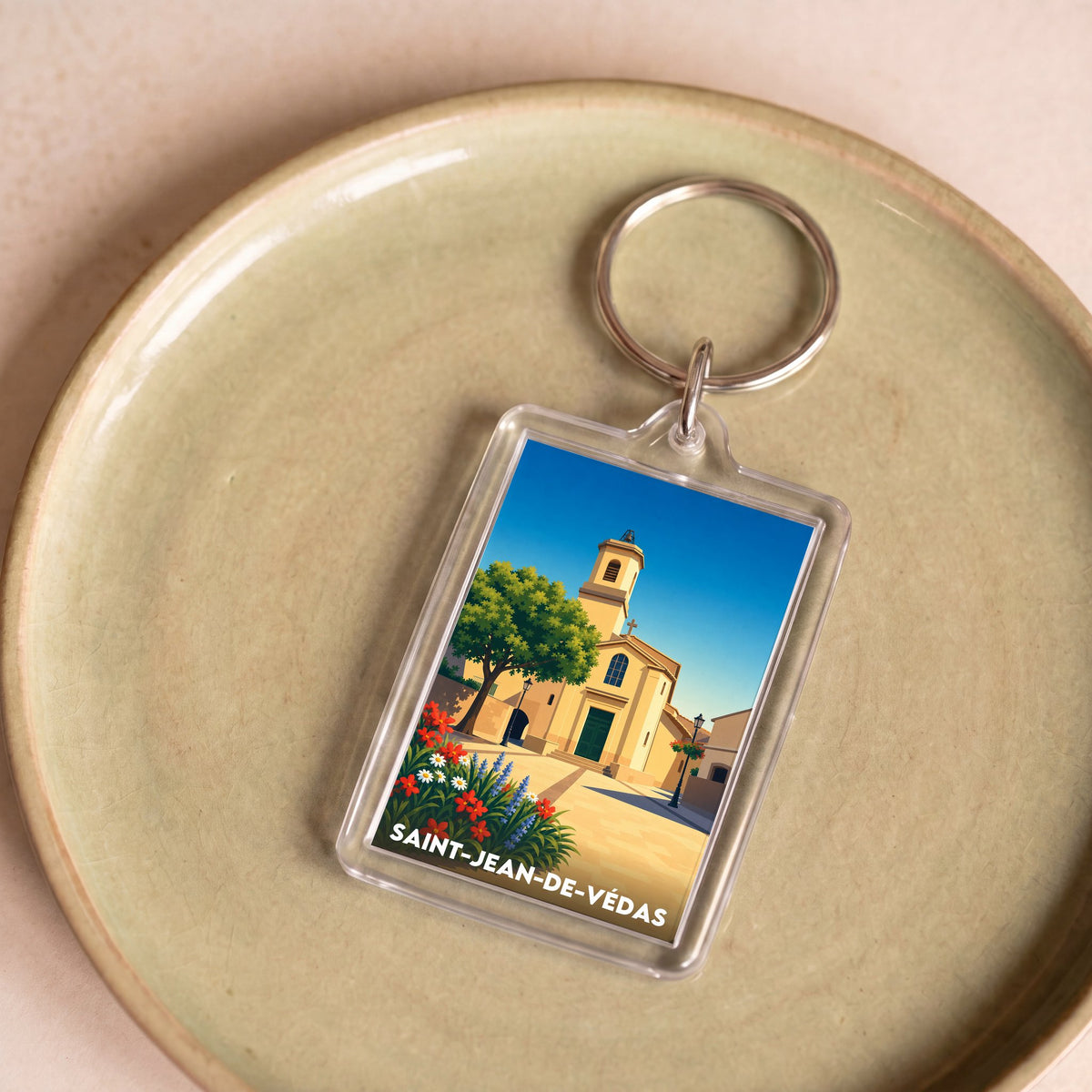 Porte-clés souvenir de la ville de Saint-Jean-de-Védas avec une illustration stylisée de son église.