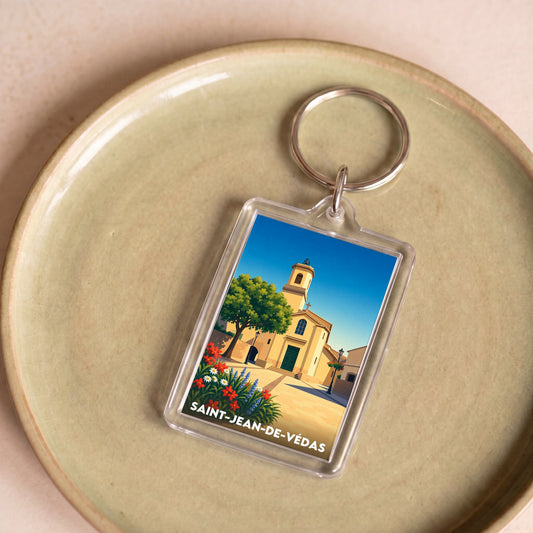 Porte-clés souvenir de la ville de Saint-Jean-de-Védas avec une illustration stylisée de son église.