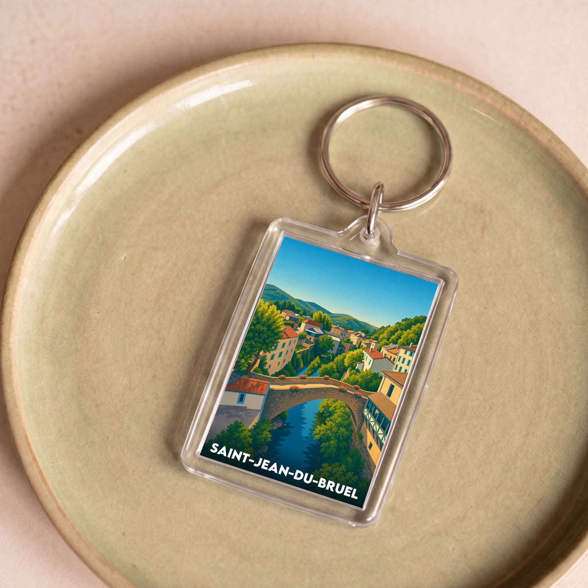 Porte-clés souvenir de la ville de Saint-Jean-du-Bruel avec une illustration stylisée.