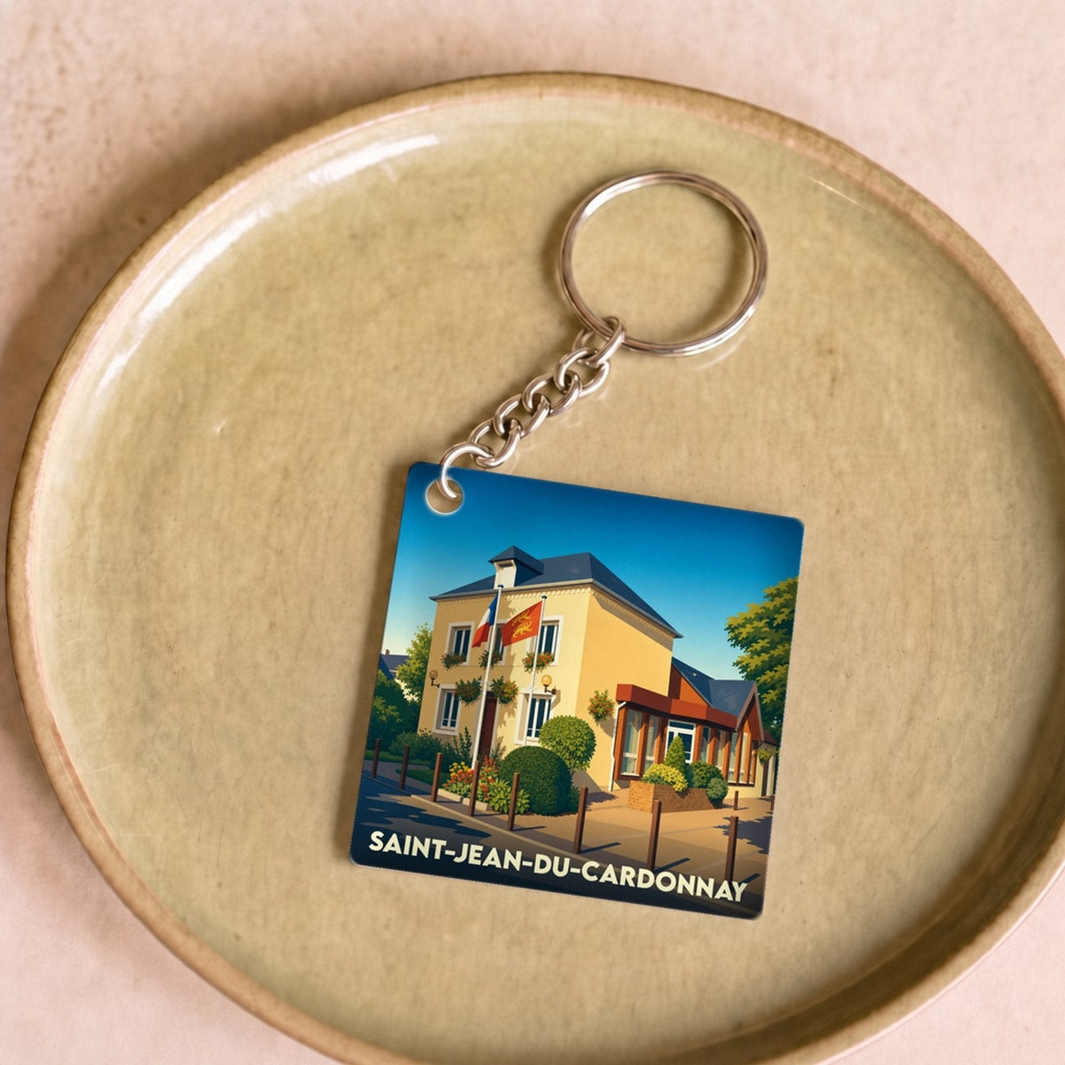 Porte-clés souvenir de la ville de Saint-Jean-du-Cardonnay avec une illustration stylisée.
