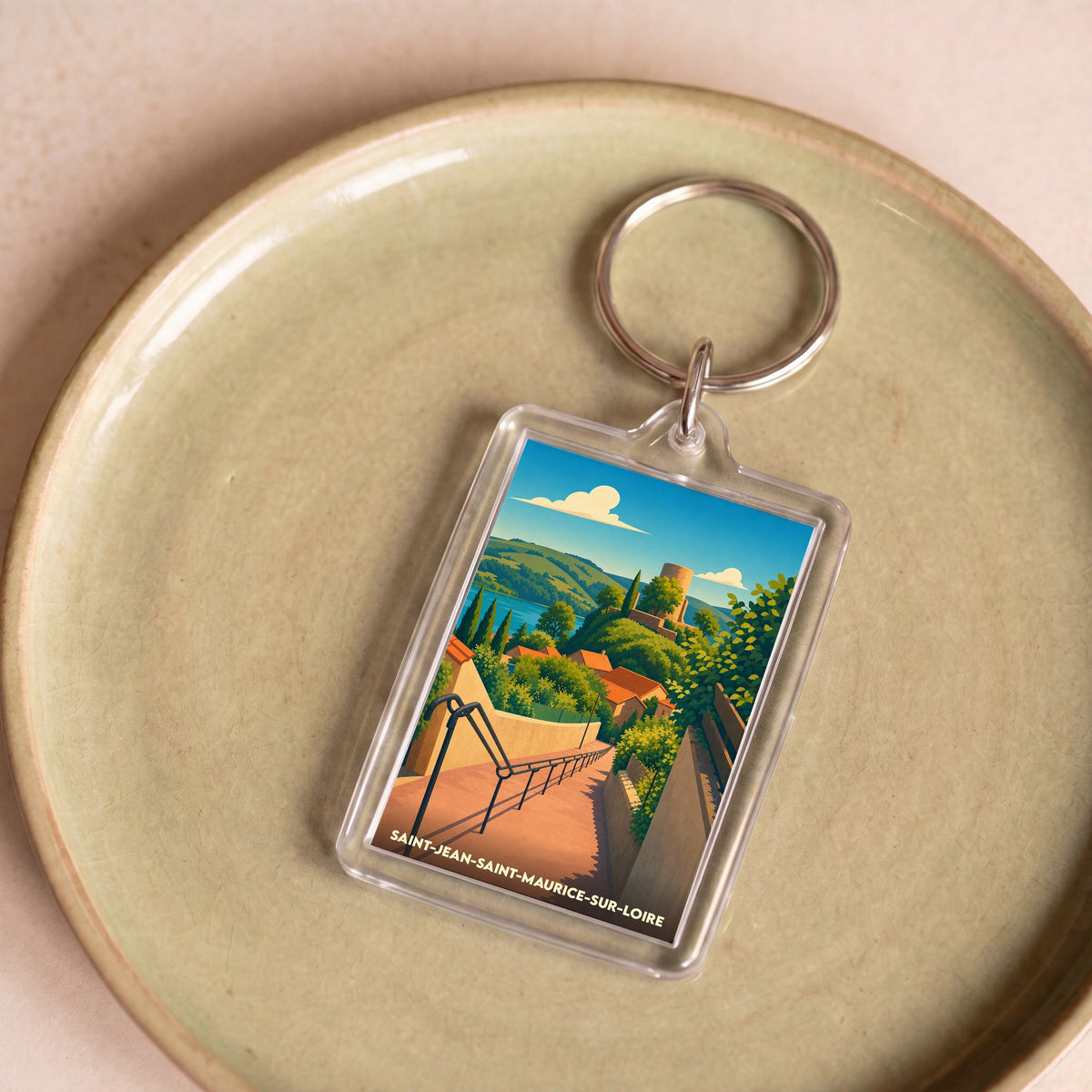 Porte-clés souvenir de la ville de Saint-Jean-Saint-Maurice-sur-Loire avec une illustration stylisée de son village médiéval.