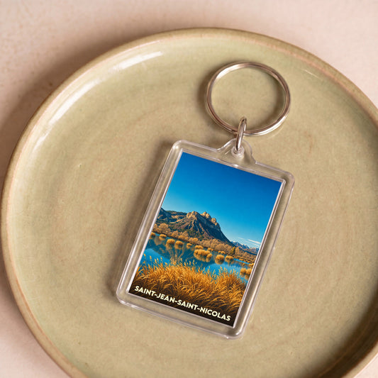 Porte-clés souvenir de la ville de Saint-Jean-Saint-Nicolas avec une photo de paysage de montagne et de lac.