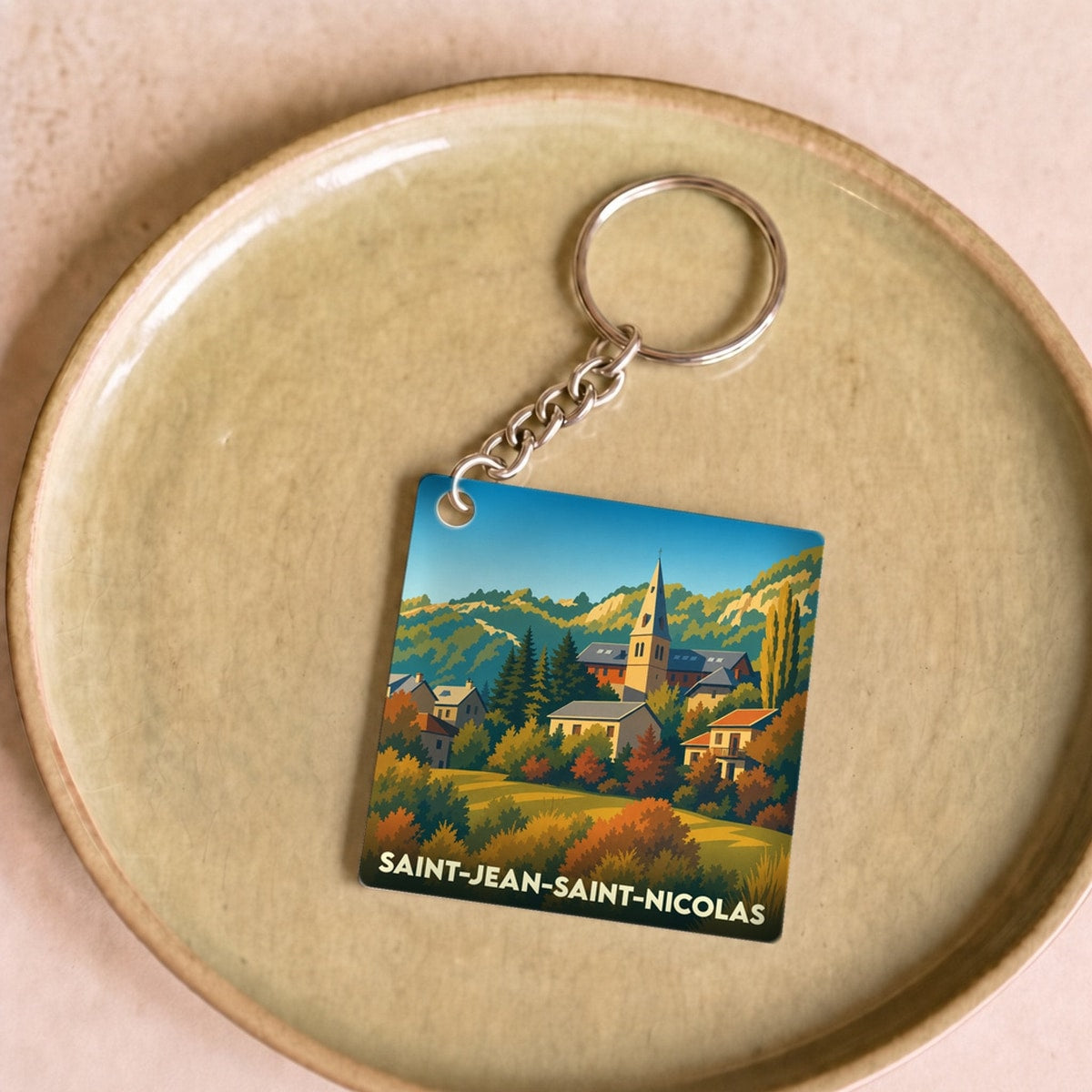 Porte-clés souvenir de la ville de Saint-Jean-Saint-Nicolas avec une illustration stylisée.
