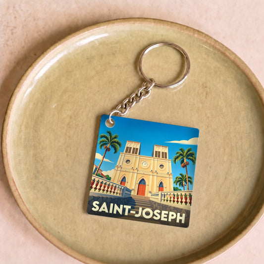 Porte-clés souvenir de la ville de Saint-Joseph avec une illustration stylisée de son église et de palmiers.