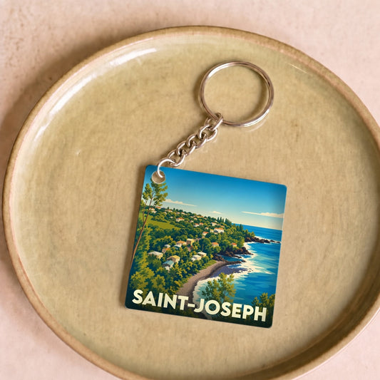 Porte-clés souvenir de la ville de Saint-Joseph avec une illustration stylisée d'un paysage côtier.