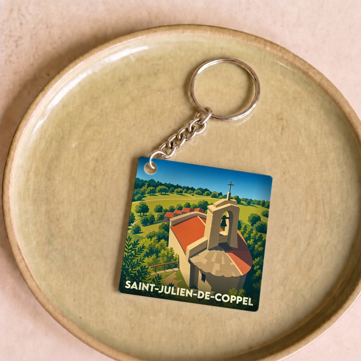 Porte-clés souvenir de la ville de Saint-Julien-de-Coppel avec une illustration stylisée.