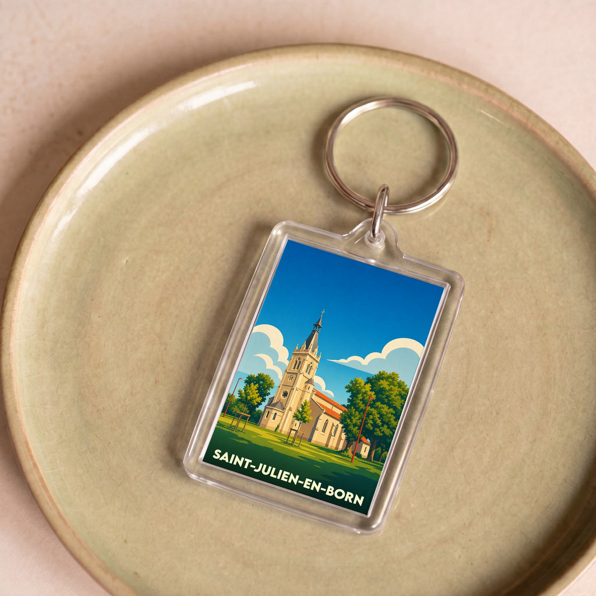 Porte-clés souvenir de la ville de Saint-Julien-en-Born avec une illustration stylisée de son église.