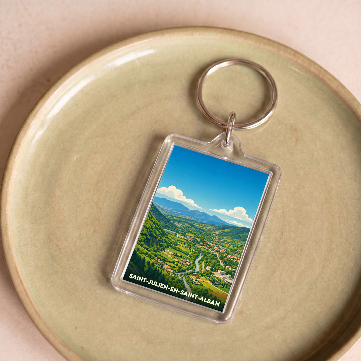Porte-clés souvenir de la ville de Saint-Julien-en-Saint-Alban avec une illustration stylisée du paysage.