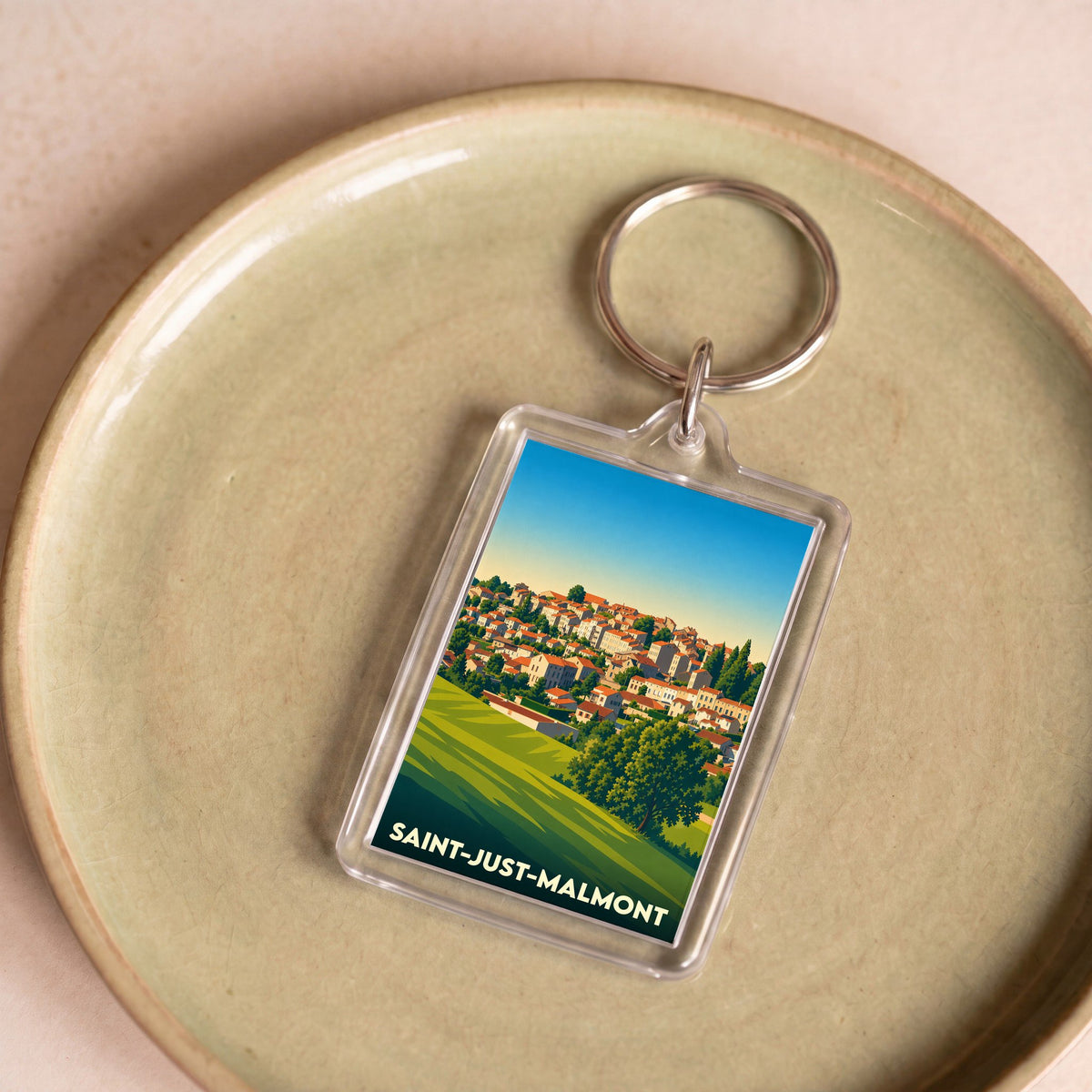 Porte-clés souvenir de la ville de Saint-Just-Malmont avec une illustration stylisée.