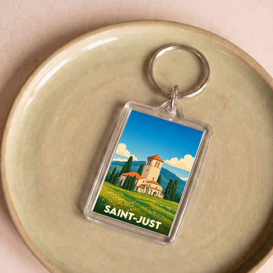 Porte-clés souvenir de la ville de Saint-Just avec une illustration stylisée d'une église et d'un paysage ensoleillé.