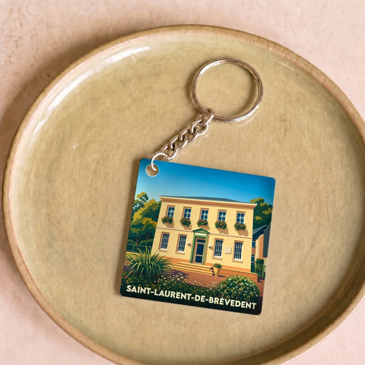 Porte-clés souvenir de la ville de Saint-Laurent-de-Brèvedent avec une illustration stylisée d'un bâtiment fleuri.