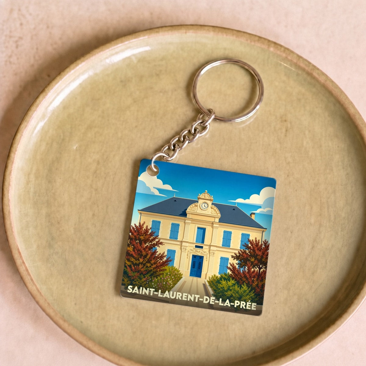 Porte-clés souvenir de la ville de Saint-Laurent-de-la-Prée avec une illustration stylisée.
