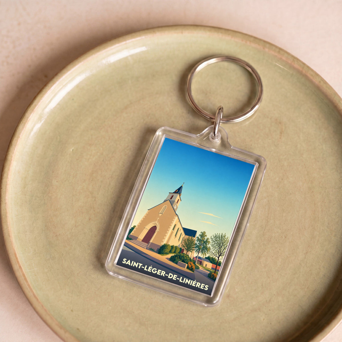 Porte-clés souvenir de la ville de Saint-Léger-de-Linières avec une illustration stylisée de son église.