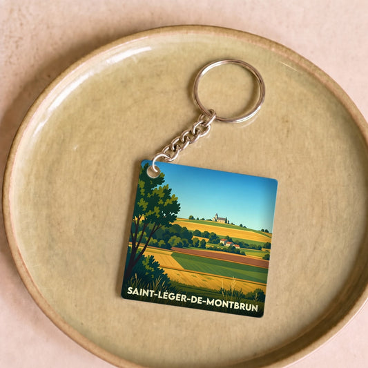 Porte-clés souvenir de Saint-Léger-de-Montbrun avec une illustration stylisée de paysages vallonnés.