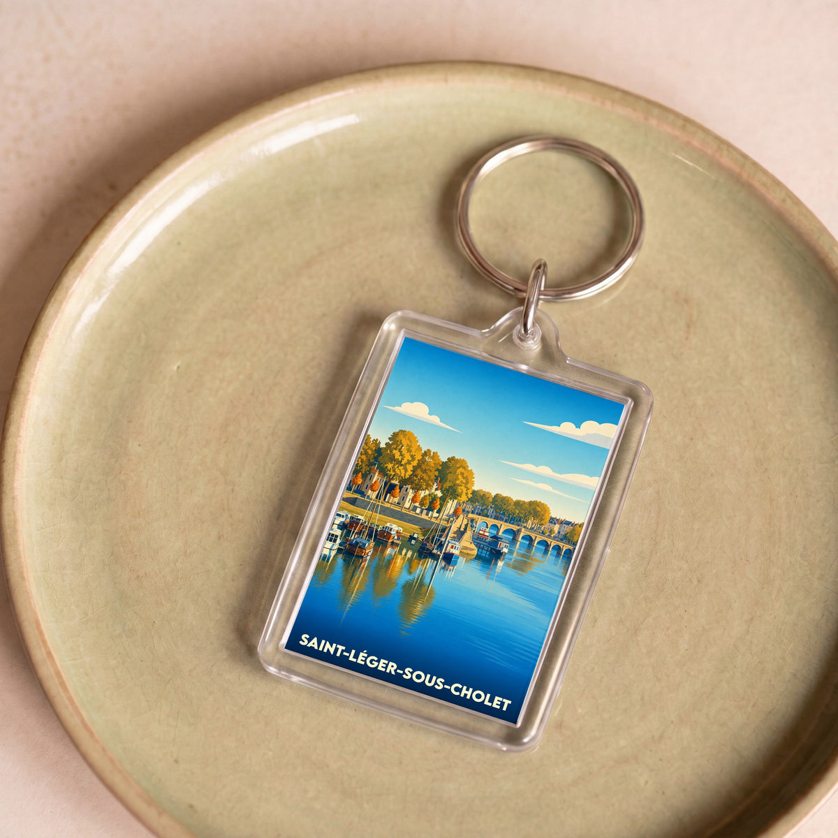 Porte-clés souvenir de la ville de Saint-Léger-sous-Cholet avec une illustration stylisée.