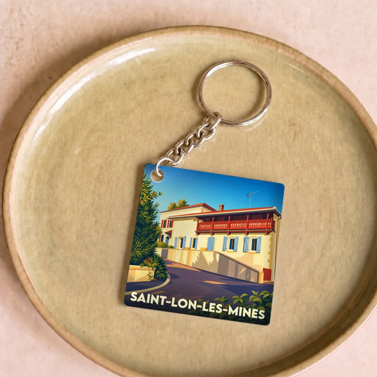 Porte-clés souvenir de la ville de Saint-Lon-les-Mines avec une illustration stylisée d'une maison landaise.