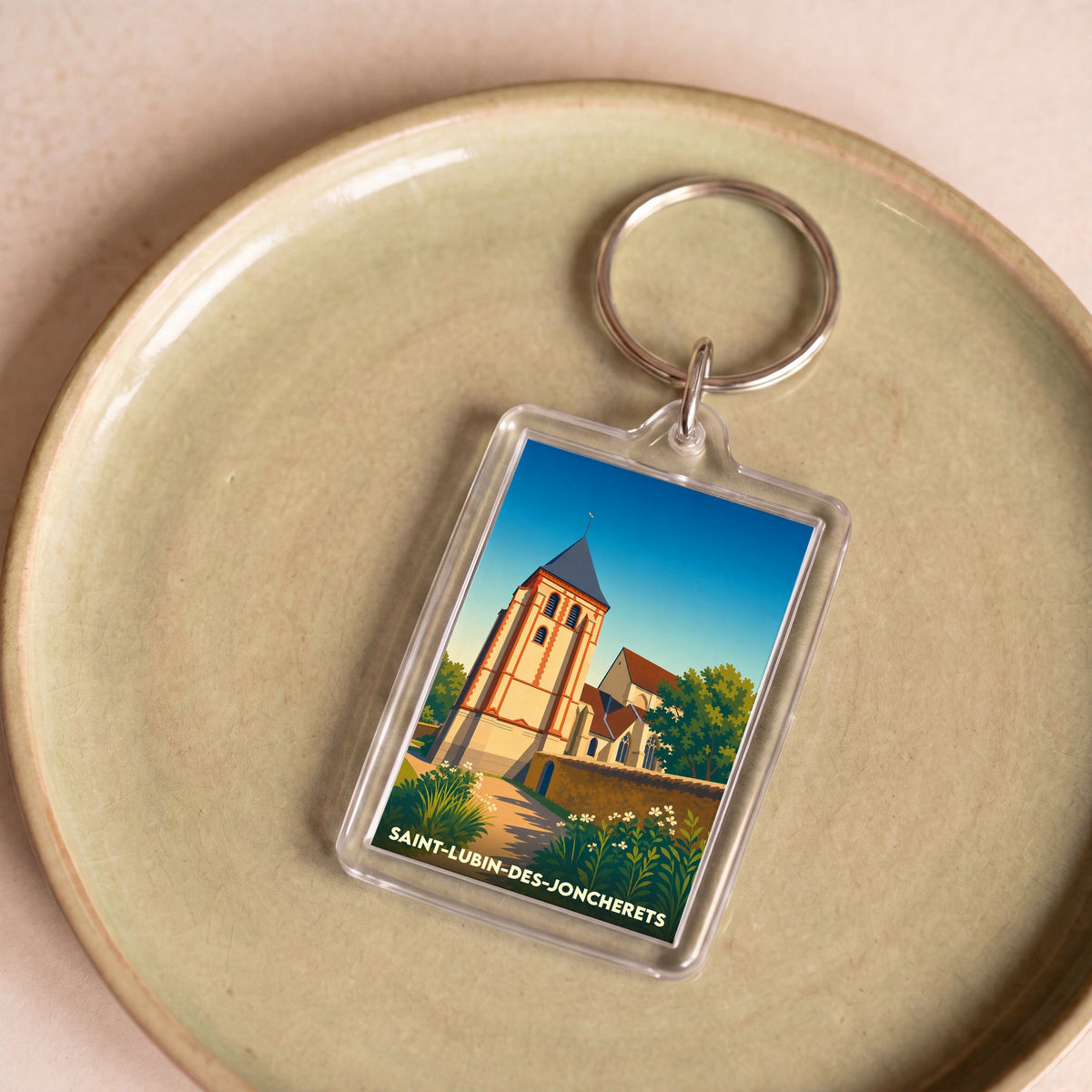 Porte-clés souvenir de la ville de Saint-Lubin-des-Joncherets avec une illustration stylisée de son église.