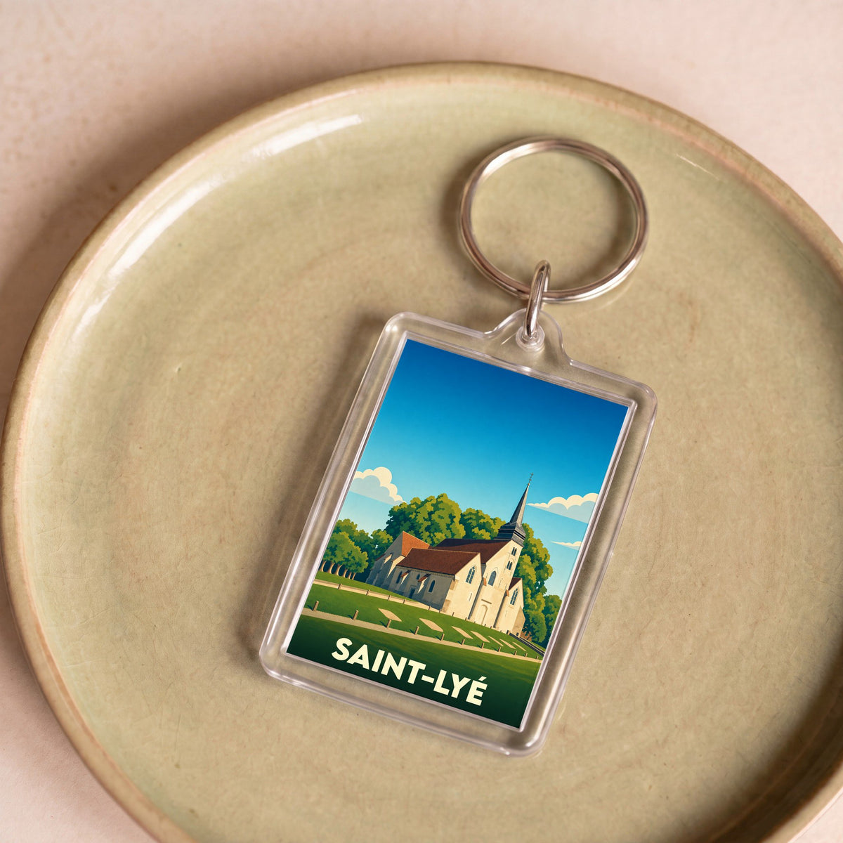 Porte-clés souvenir de la ville de Saint-Lyé avec une illustration stylisée de son église.