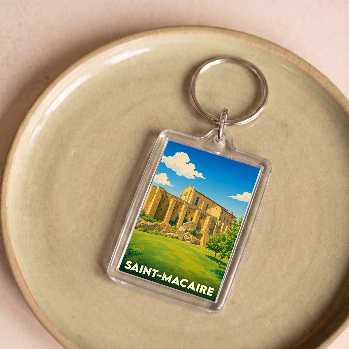Porte-clés souvenir de la ville de Saint-Macaire avec une illustration stylisée.