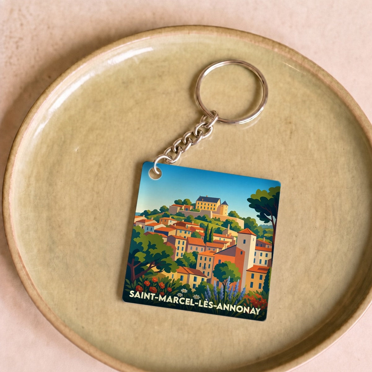 Porte-clés souvenir de la ville de Saint-Marcel-lès-Annonay avec une illustration stylisée et colorée.