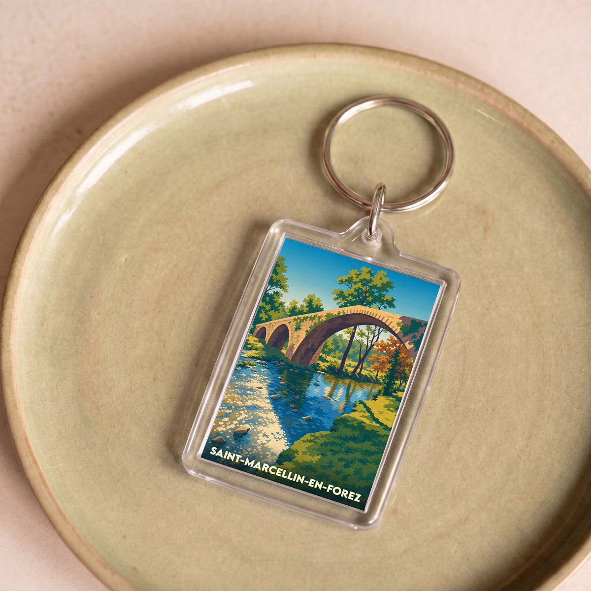 Porte-clés souvenir de la ville de Saint-Marcellin-en-Forez avec une illustration stylisée d'un pont en pierre.