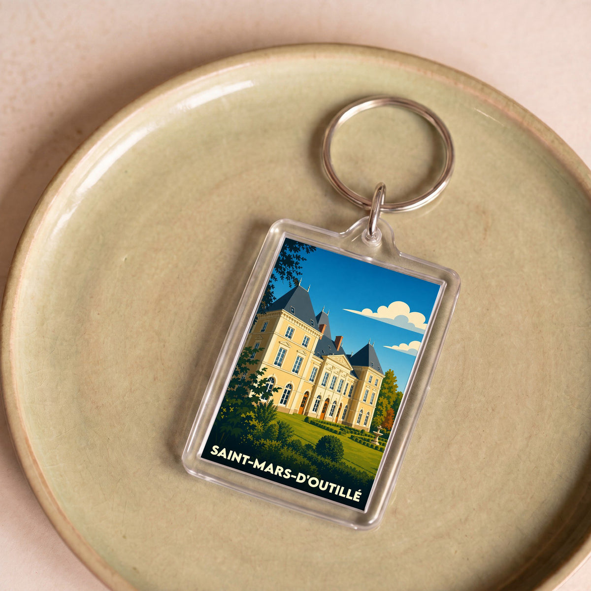 Porte-clés souvenir de la ville de Saint-Mars-d'Outillé avec une illustration stylisée de son château.