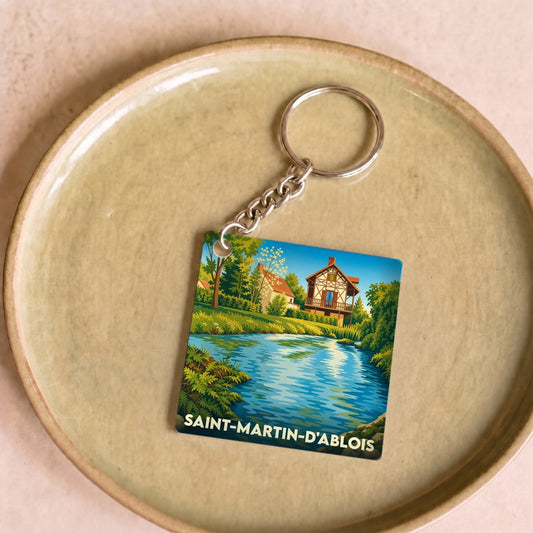 Porte-clés souvenir de la ville de Saint-Martin-d'Ablois avec une illustration stylisée d'un paysage de bord d'eau.