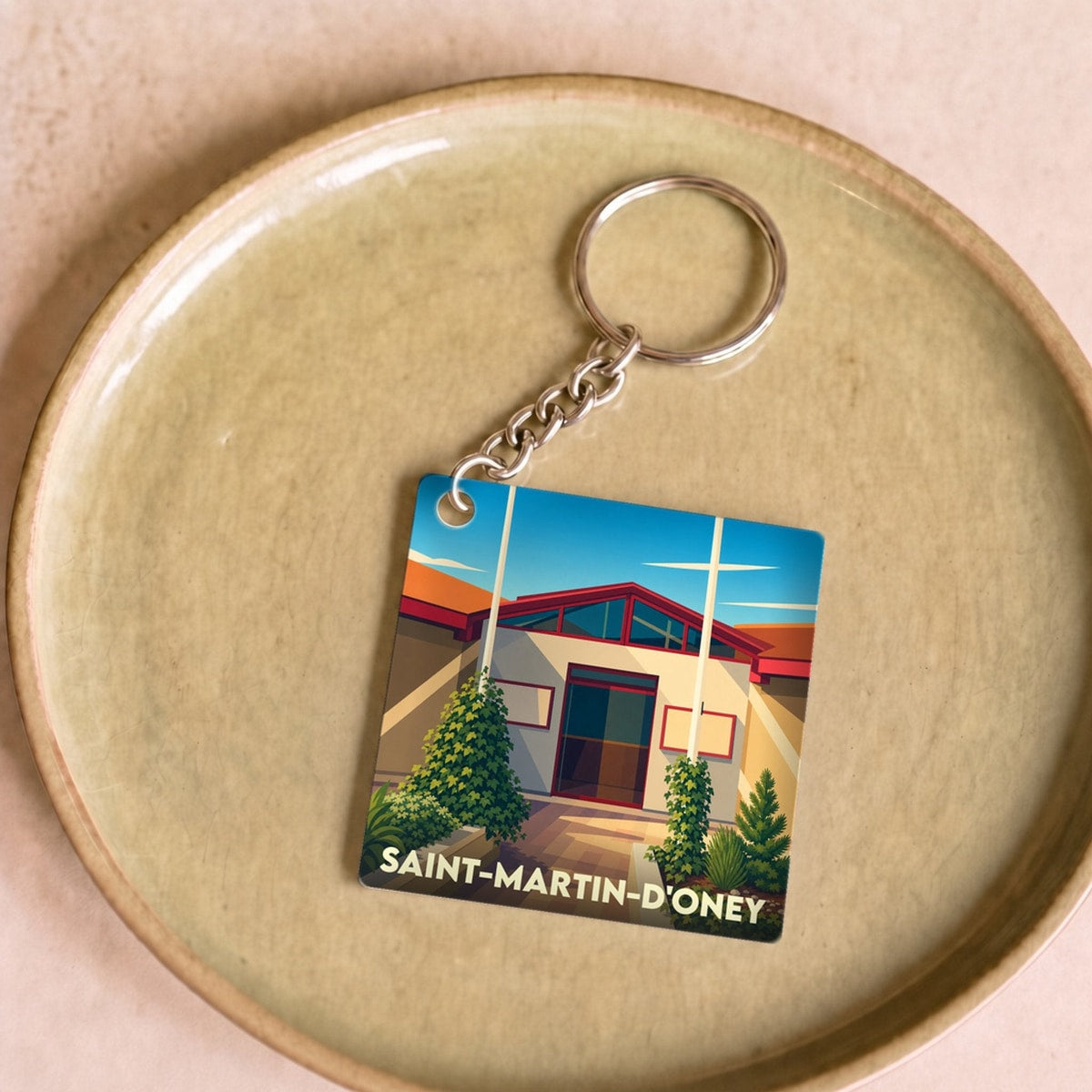 Porte-clés souvenir de la ville de Saint-Martin-d'Oney avec une illustration stylisée.