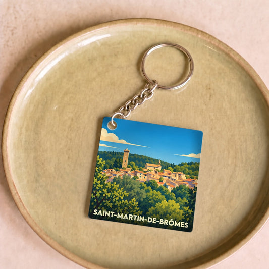Porte-clés souvenir de Saint-Martin-de-Brômes avec une illustration stylisée du village et de sa tour.