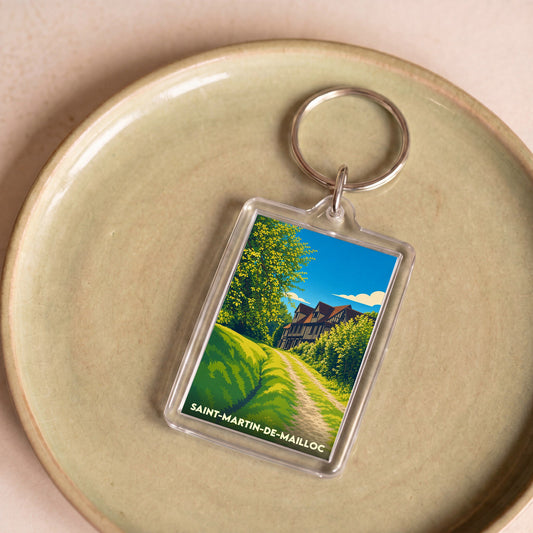 Porte-clés souvenir de Saint-Martin-de-Mailloc avec une illustration stylisée d'un manoir normand.