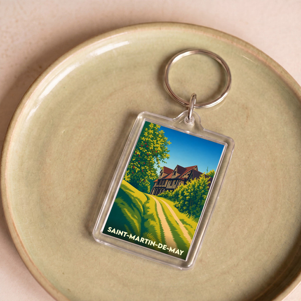 Porte-clés souvenir de la ville de Saint-Martin-de-May avec une illustration stylisée.