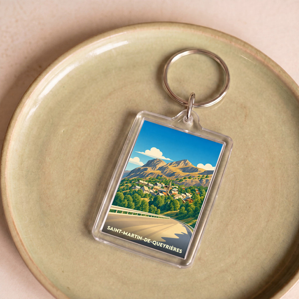 Porte-clés souvenir de la ville de Saint-Martin-de-Queyrières avec une illustration de paysage de montagne.