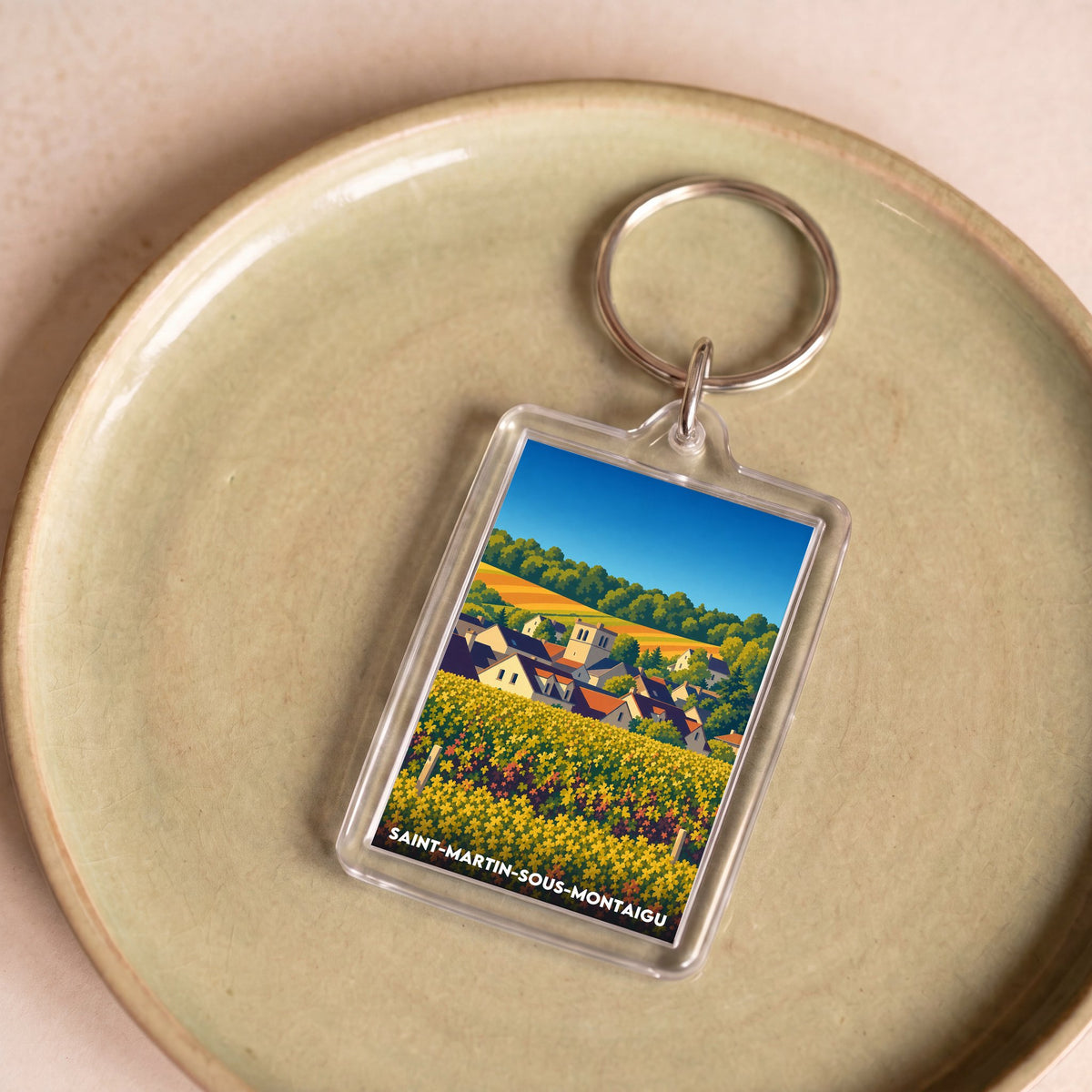 Porte-clés souvenir de Saint-Martin-sous-Montaigu avec une illustration stylisée du village.