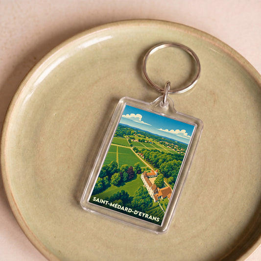 Porte-clés souvenir de la ville de Saint-Médard-d'Eyrans avec une illustration paysagère stylisée.