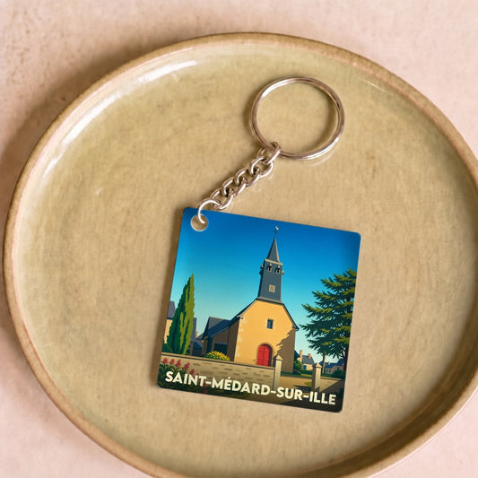 Porte-clés souvenir de la ville de Saint-Médard-sur-Ille avec une illustration stylisée de son église.