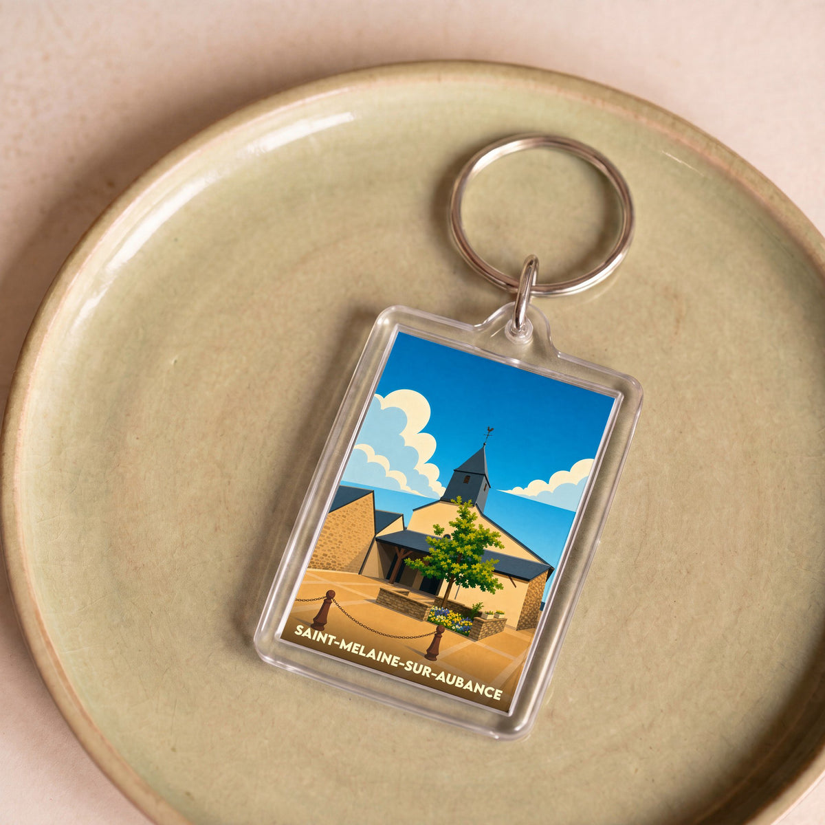 Porte-clés souvenir de la ville de Saint-Melaine-sur-Aubance avec une illustration stylisée.