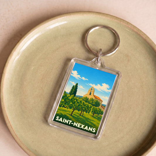 Porte-clés souvenir de la ville de Saint-Nexans avec une illustration stylisée d'un paysage ensoleillé.