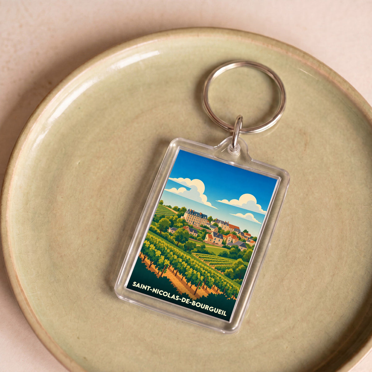 Porte-clés souvenir de la ville de Saint-Nicolas-de-Bourgueil avec une illustration stylisée de son paysage viticole.