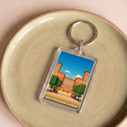 Porte-clés souvenir de la ville de Saint-Nicolas-de-la-Grave avec une illustration stylisée de son château.