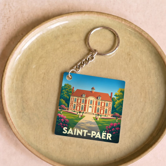 Porte-clés souvenir de la ville de Saint-Paër avec une illustration stylisée d'un château.