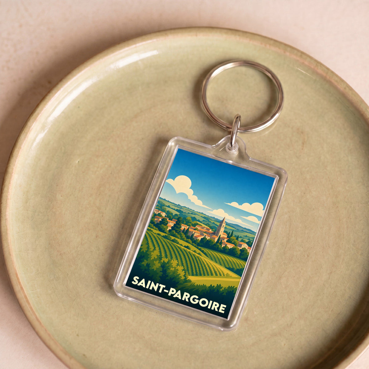 Porte-clés souvenir de la ville de Saint-Pargoire avec une illustration stylisée de vignes et du village.