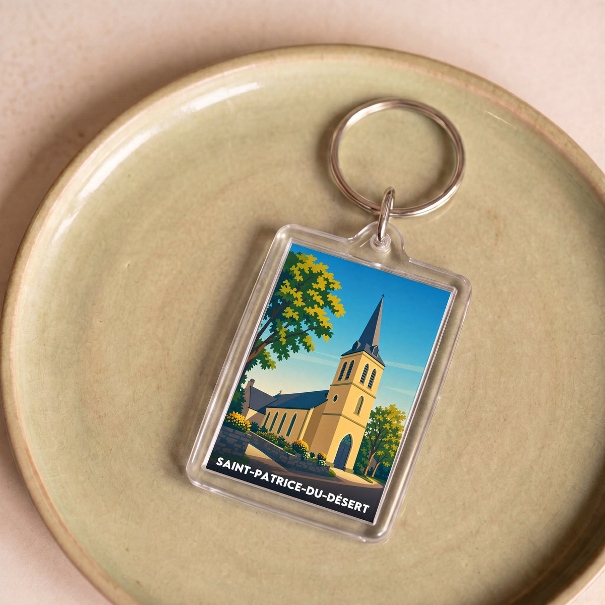 Porte-clés souvenir de la ville de Saint-Patrice-du-Désert avec une illustration stylisée d'une église.