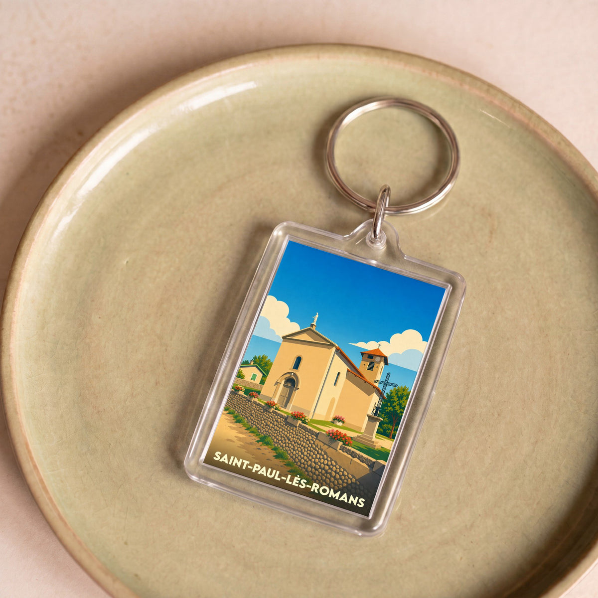 Porte-clés souvenir de la ville de Saint-Paul-lès-Romans avec une illustration stylisée de son église.
